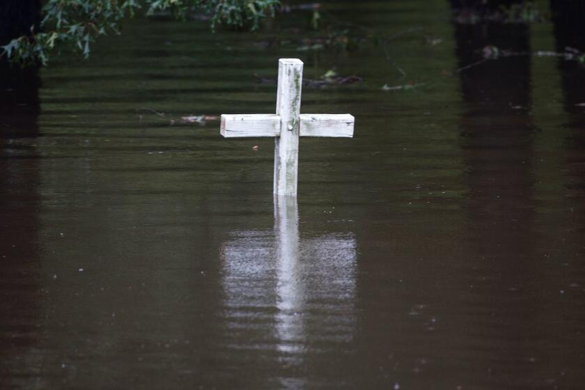 A cross is seen in flood water at a cemetary in Grifton, North Carolina on September 16, 2018. - A killer storm that left up to 13 people dead weakened to a tropical depression on Sunday, but US authorities warned the devastation it caused -- including catastrophic flooding -- is far from over.Most of the fatalities from Florence, which made landfall Friday as a Category 1 hurricane, have occurred in North Carolina, where officials confirmed eight victims. They included three who died "due to flash flooding and swift water on roadways," the Duplin County Sheriff's Office reported. (Photo by Andrew CABALLERO-REYNOLDS / AFP)ANDREW CABALLERO-REYNOLDS/AFP/Getty Images ** OUTS - ELSENT, FPG, CM - OUTS * NM, PH, VA if sourced by CT, LA or MoD **