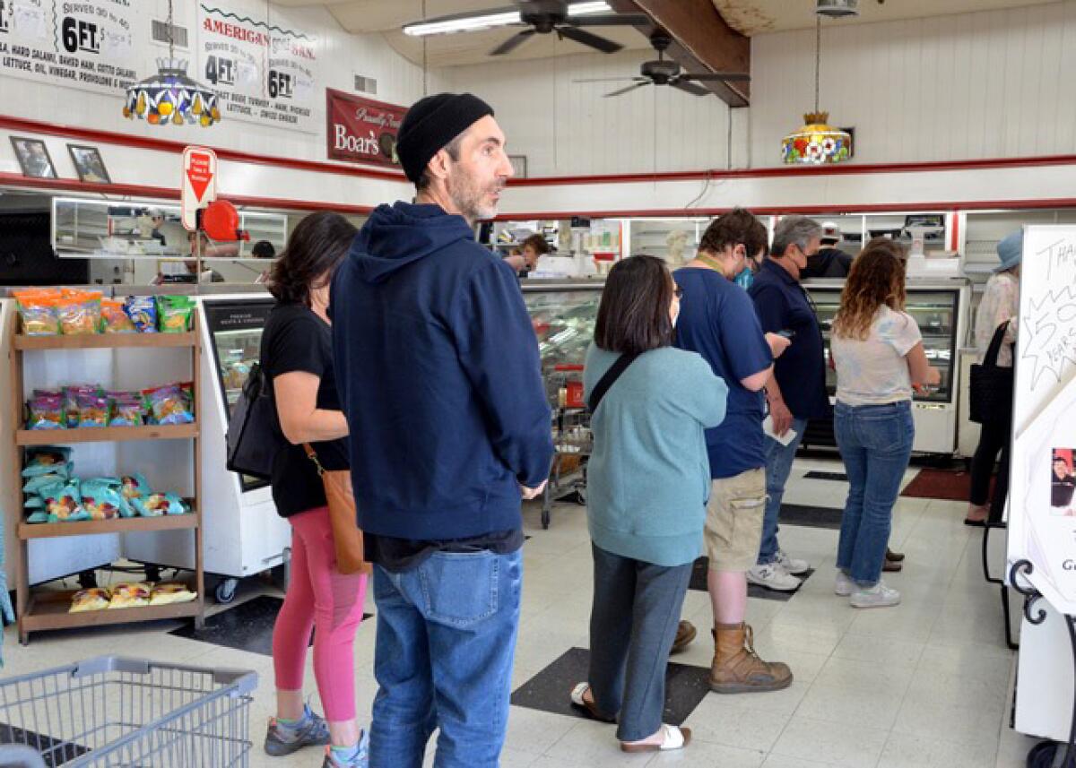 Longtime Lucci's loyal customer, Ross Balocco, center, waits in the bakery line last Friday to make a final purchase.