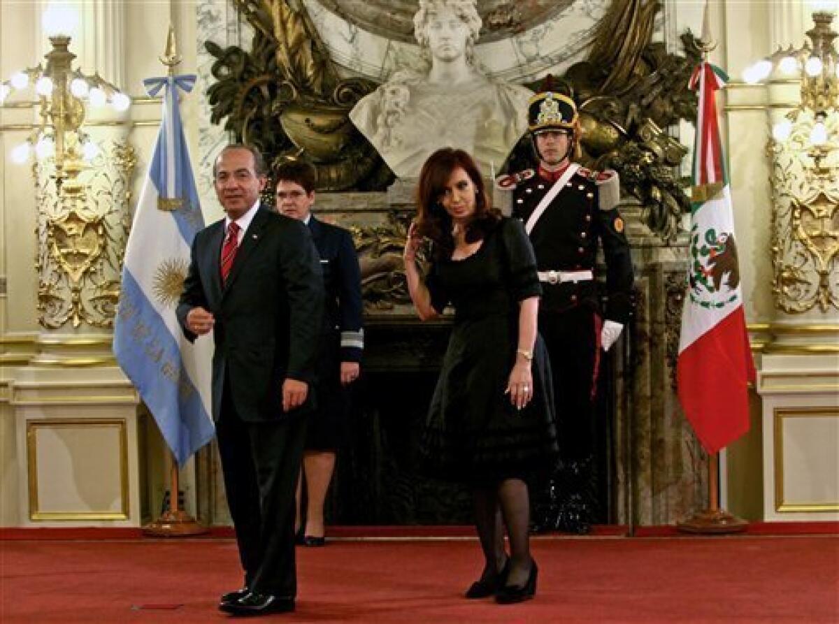 Mexico's President Felipe Calderon, left, and Argentina's President Cristina Fernandez gesture before the inauguration of a mural painted by Mexican artist David Alfaro Siqueiros at the government house in Buenos Aires, Argentina, Friday, Dec. 3, 2010. The mural entitled "Ejercicio Plastico", has been placed at the future Museum of Political Arts, a former underground customs facility, next to the government house. (AP Photo/Ivan Fernandez)