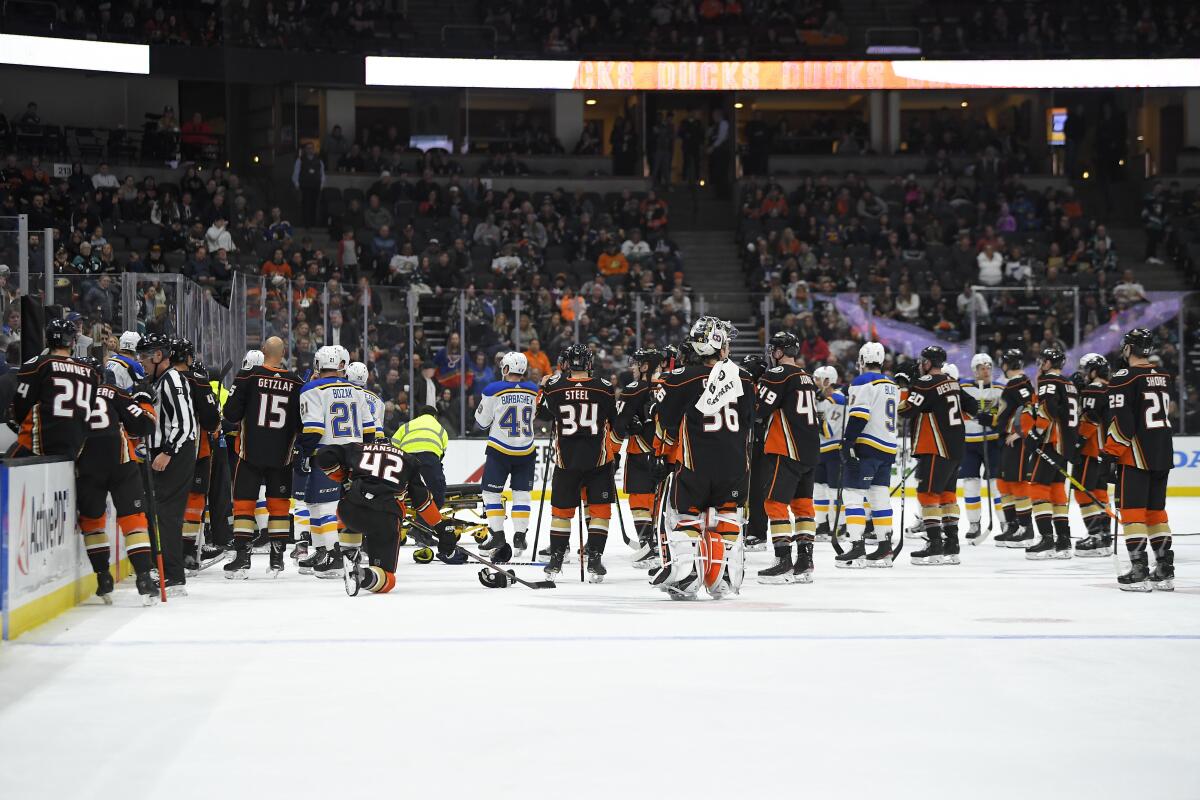 Ducks and Blues players gather on the ice after Jay Bouwmeester went into cardiac arrest while on the bench.