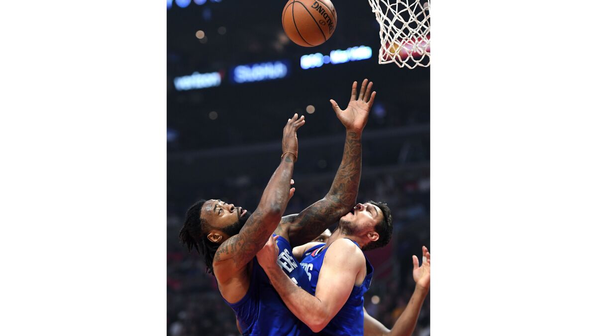 Clippers Danilo Gallinari gets an elbow to the face from teamate DeAndre Jordan while battling for a rebound.