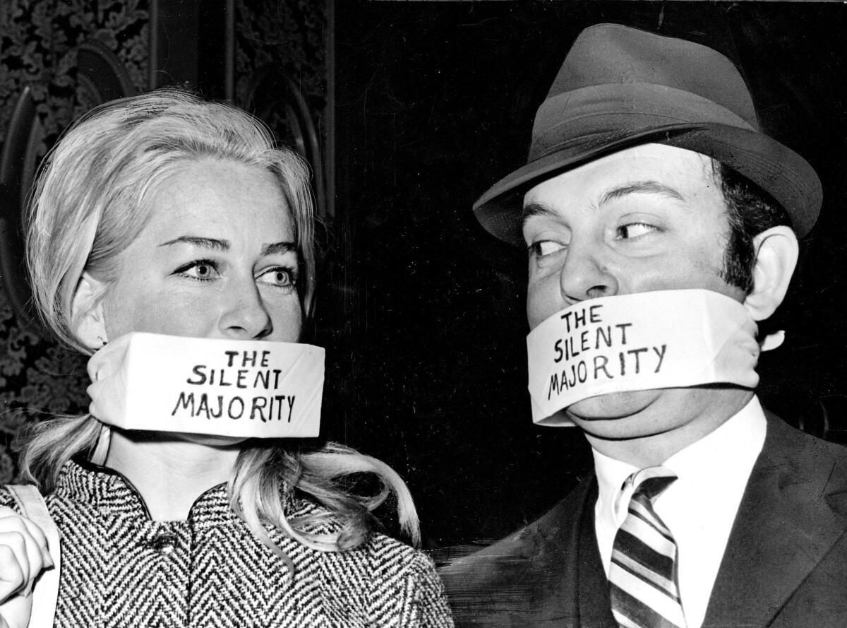 Nancy Ross and John Joannes wear gags labeled "the silent majority" at the 1970 Bachelors Ball. The event has been held at the Beverly Hilton hotel for more than five decades.