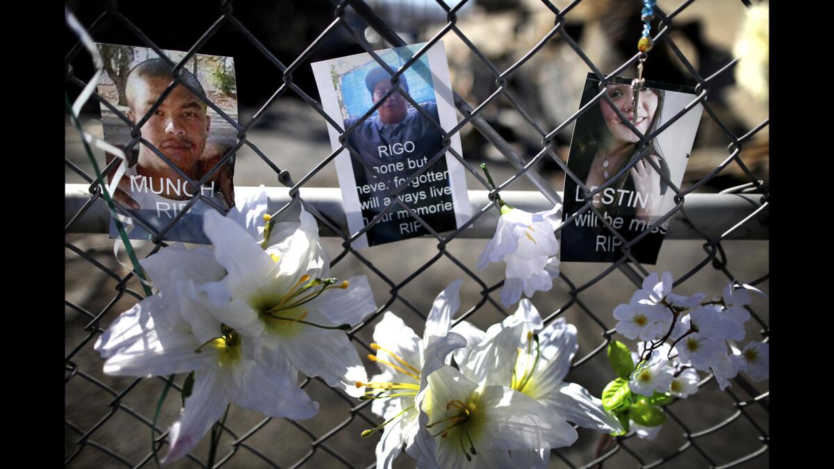 Photos of the three slain youths are displayed on a fence outside the South El Monte tire shop where the killings occurred.