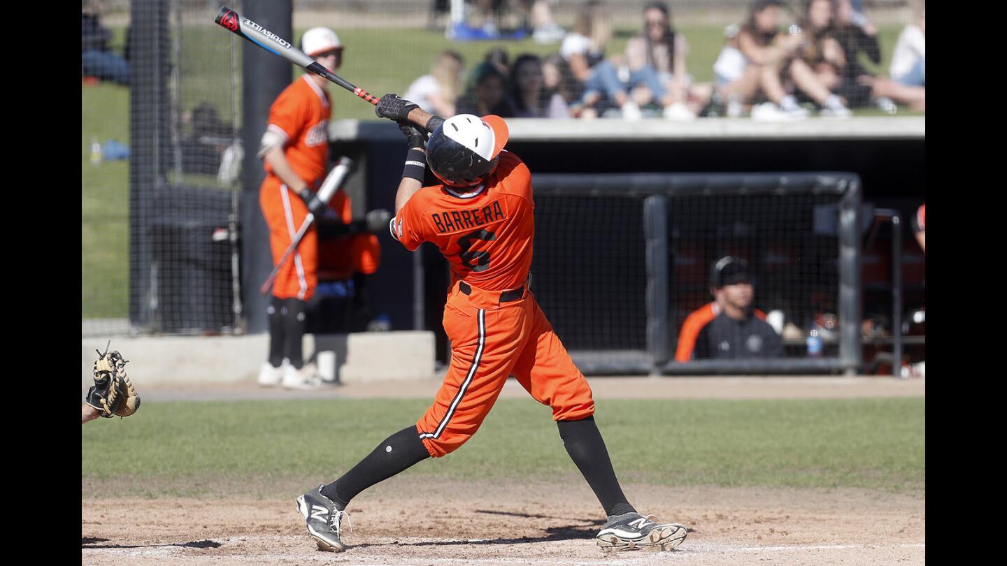 Huntington Beach High's Brett Barrera hits a solo homer against Fountain Valley during the second inning in a Surf League game at Huntington Beach High on Friday, March 15, 2019.