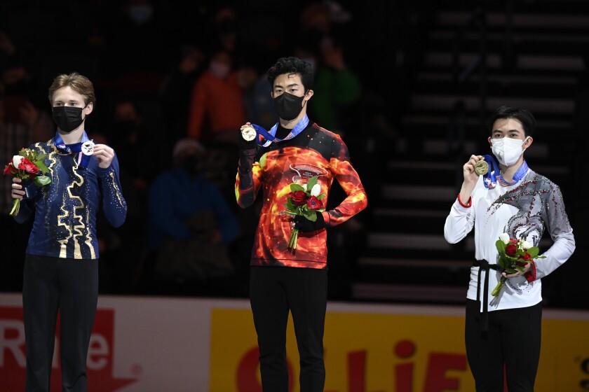 First place, Nathan Chen stands with second place, Ilia Malinin left, third place, Vincent Zhou during the medal ceremony for the men's free skate program during the U.S. Figure Skating Championships Sunday, Jan. 9, 2022, in Nashville, Tenn. (AP Photo/Mark Zaleski)