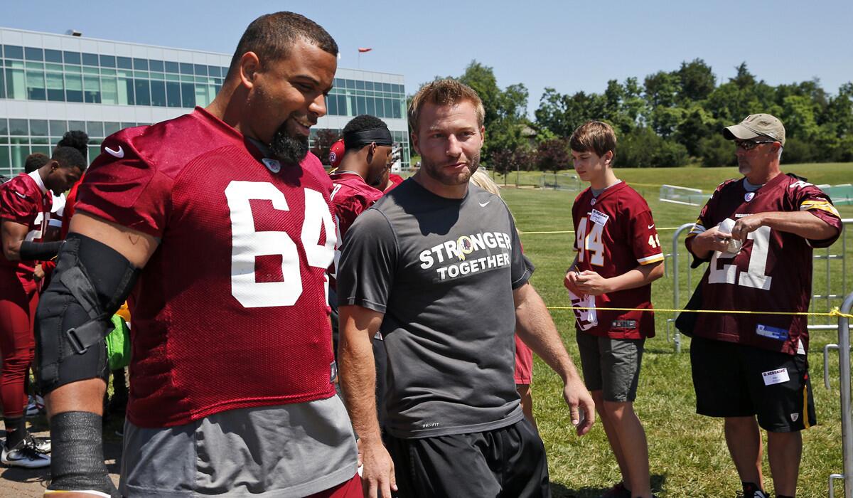 Washington Redskins offensive coordinator Sean McVay talks with nose tackle Kedric Golston (64) as they walk to practice last June.