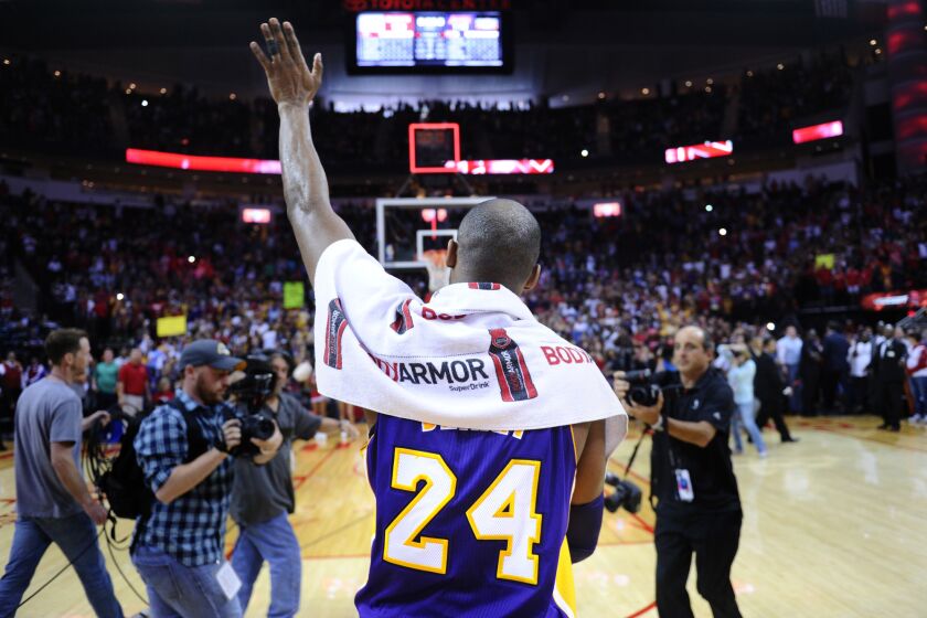 Los Angeles Lakers star Kobe Bryant waves goodbye to fans after a game Sunday against the Rockets in Houston.