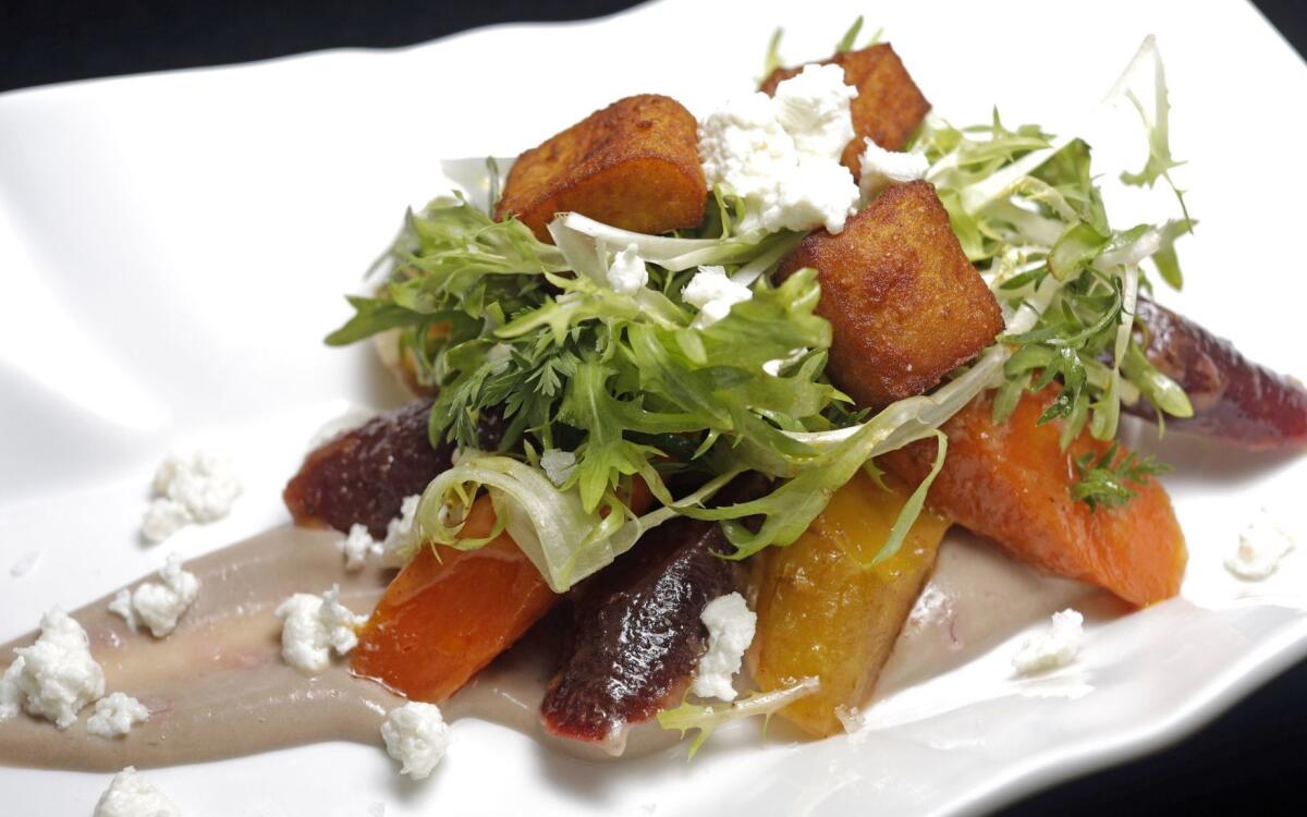 Station's carrot salad with pomegranate curd, fresh cheese, chickpea fritters, bitter greens and harissa vinaigrette