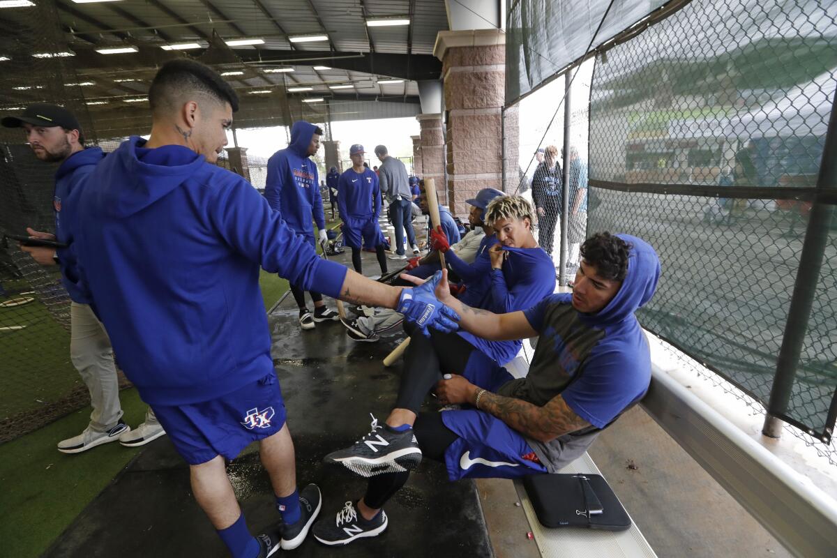 Texas Rangers minor league players Chris Seise, right, and Kevin Mendoza greet one another at spring training on March 12.