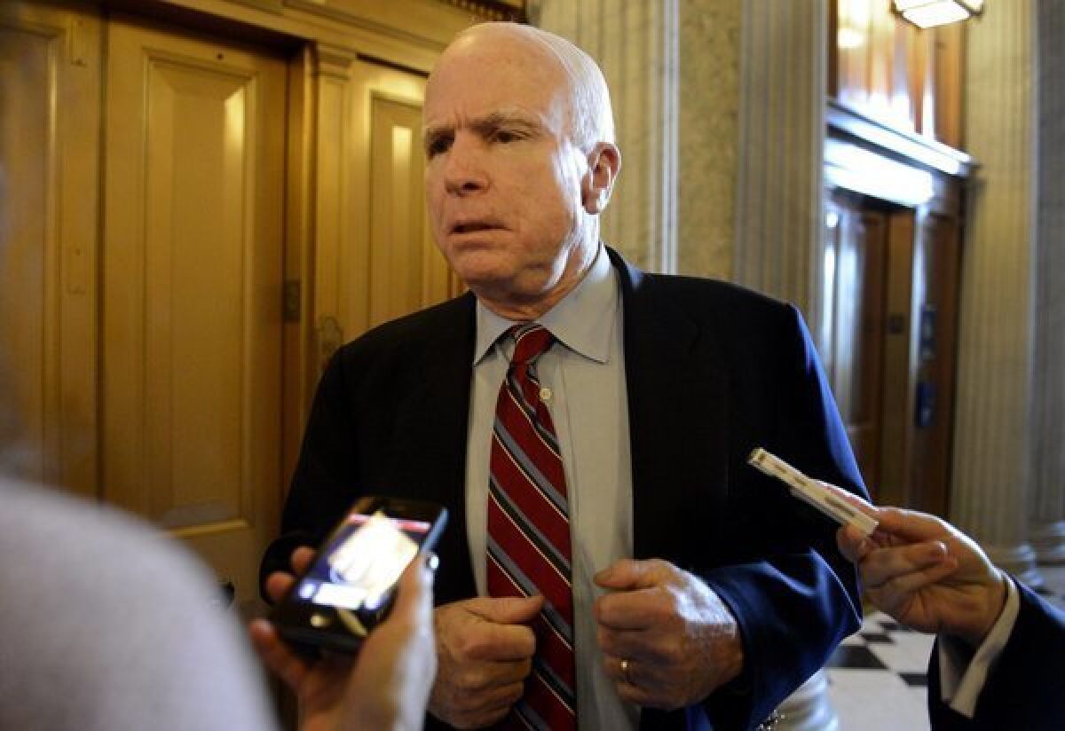 Sen. John McCain speaks with members of the media outside the Senate chamber.