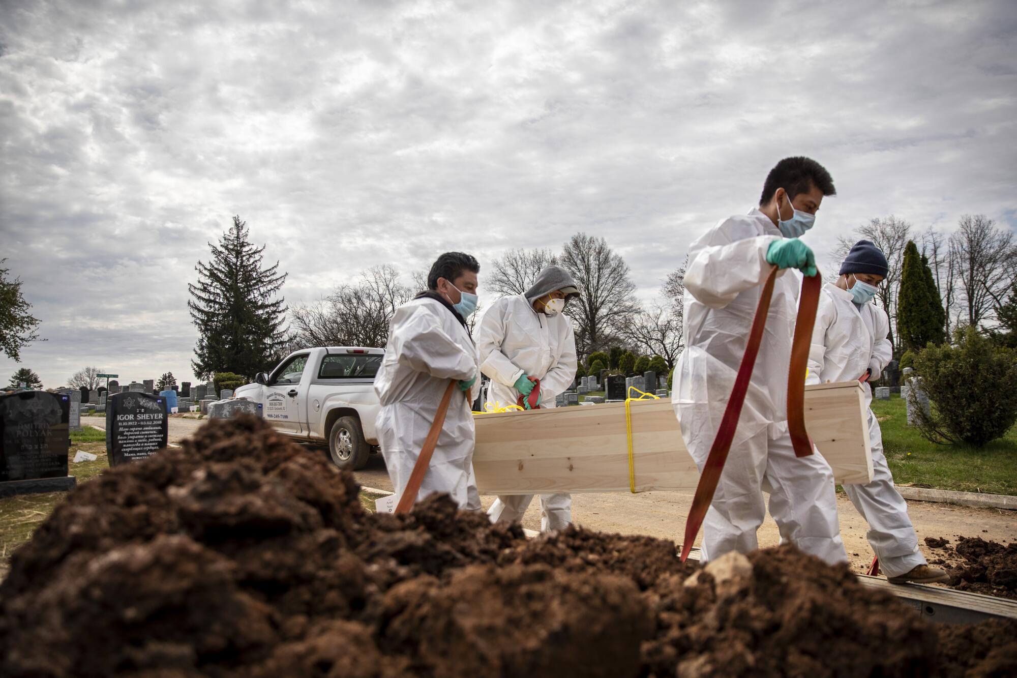 Gravediggers carry a casket April 7 at Mount Richmond Cemetery on Staten Island in New York.