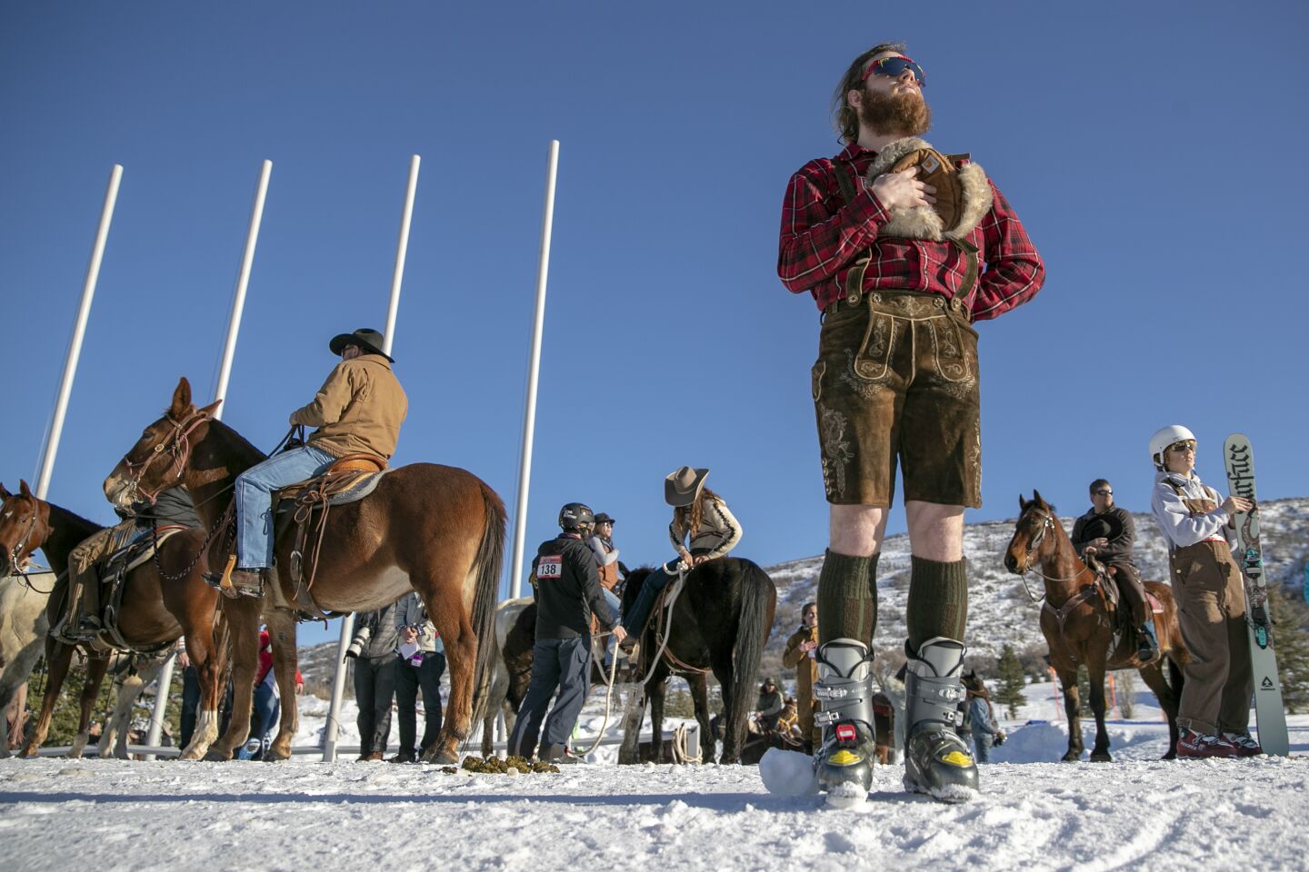 Caden Spencer stands for the national anthem at the start of Skijoring Utah. Riders and skiers team up to compete in a two-day rodeo-like event in which skiers are pulled through an obstacle course by a rope attached to a horse and rider at Soldier Hollow Nordic Center.