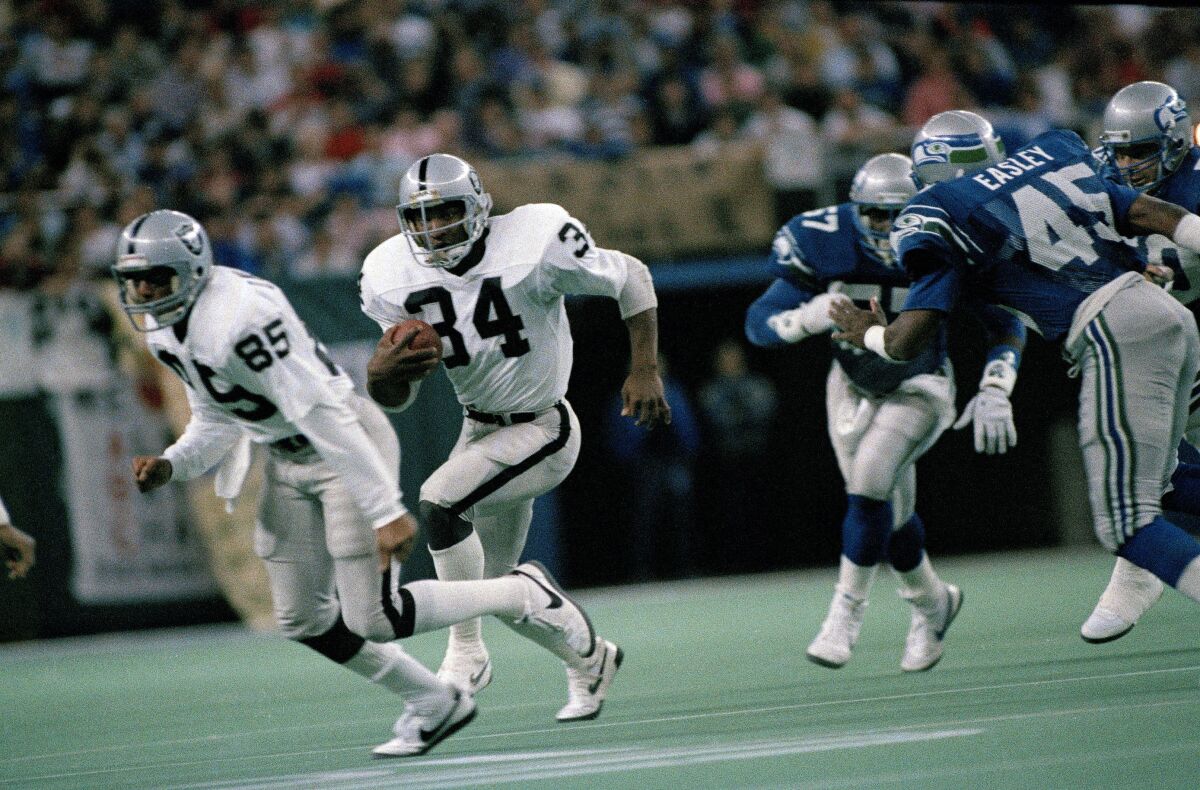 Raiders running back Bo Jackson follows Dokie Williams for a four yard gain against the Seahawks 