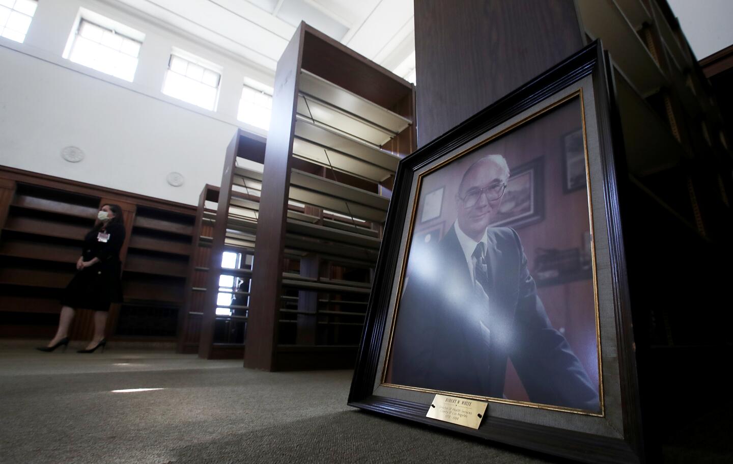 A framed portrait of former L.A. County Director of Health Services Robert W. White sits on the floor of a room.