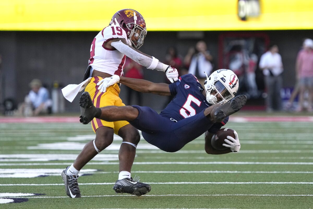 USC defensive back Jaylin Smith, left, tackles Arizona wide receiver Dorian Singer during a game on Oct. 29.