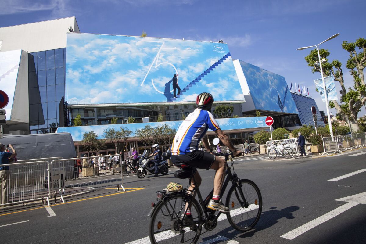 A cyclist rides past the Palais des Festivals prior to the 75th international film festival, Cannes, southern France, Monday, May 16, 2022. The Cannes film festival runs from May 17 until May 28. (Photo by Vianney Le Caer/Invision/AP)