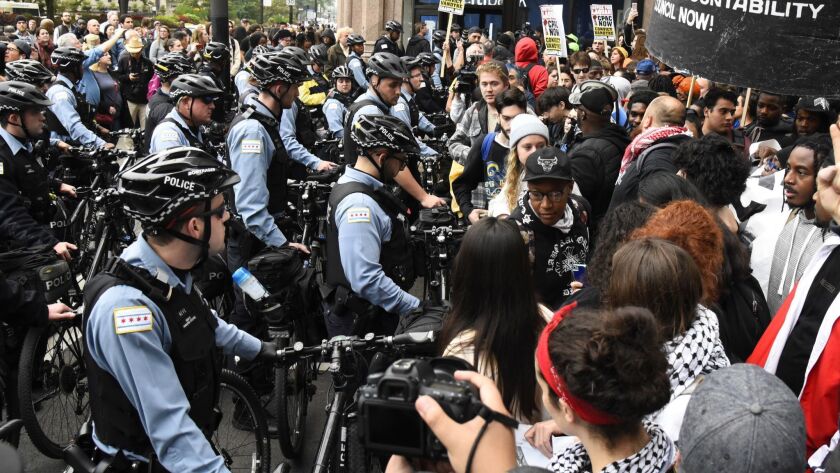 Protesters stand near police in Chicago after a jury convicted white police Officer Jason Van Dyke of second-degree murder in the 2014 shooting of black teen Laquan McDonald. Video released Tuesday shows a Chicago police officer shooting an unarmed autistic black man in 2017.
