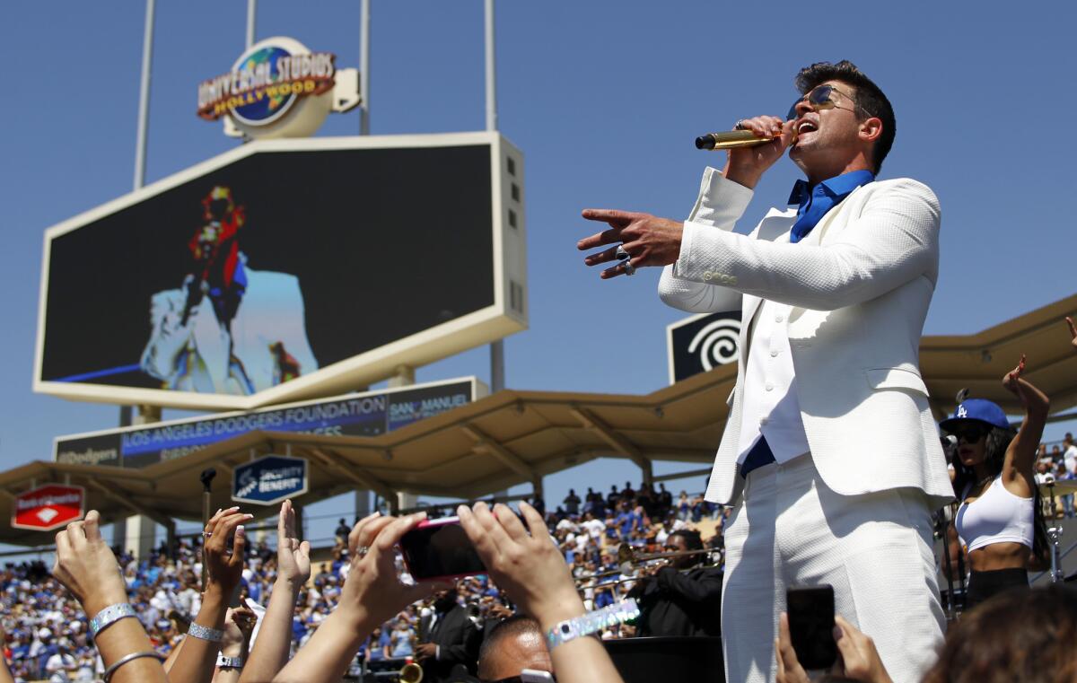 Robin Thicke performs on the field prior to a baseball game between the San Francisco Giants and Los Angeles Dodgers on April 5 in Los Angeles.