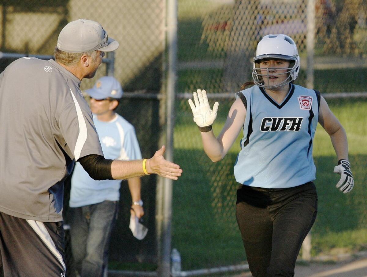 Crescenta Valley-Foothill's Sophie Georges, right, high fives her coach Will Thayer after hitting a two-run homer in a 12-1 win over West Lancaster.