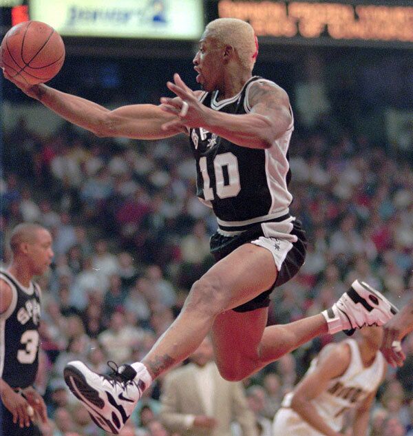 After seven years with the Pistons, Rodman was dealt to the San Antonio Spurs. Here he is seen flying through the air to pull in a rebound in the first quarter of the Spurs' opening-round playoff series against the Denver Nuggets in 1995.