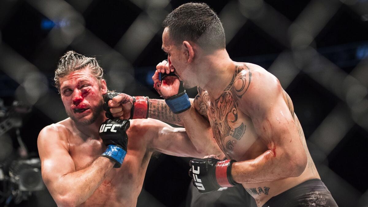 Max Holloway, right, fights Brian Ortega during the featherweight championship bout at UFC 231 in Toronto.