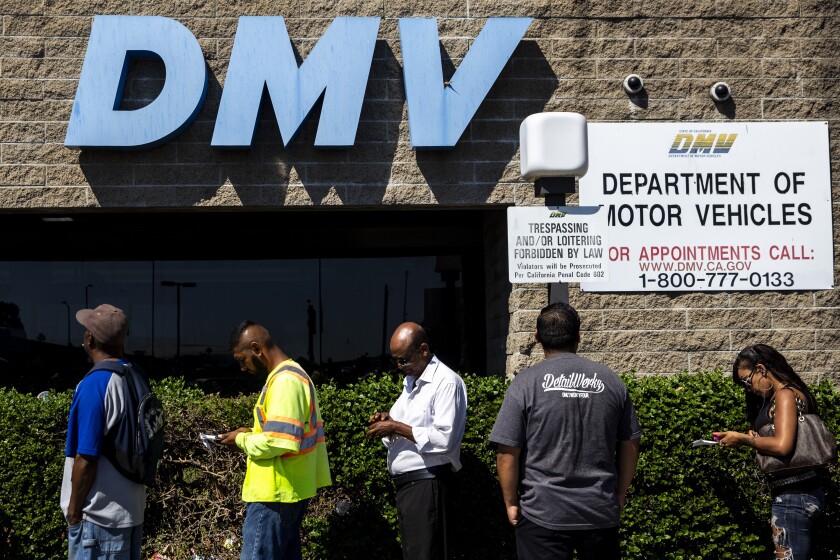 Five people wait in line outside the California DMV office in South Los Angeles on Aug. 7, 2018.