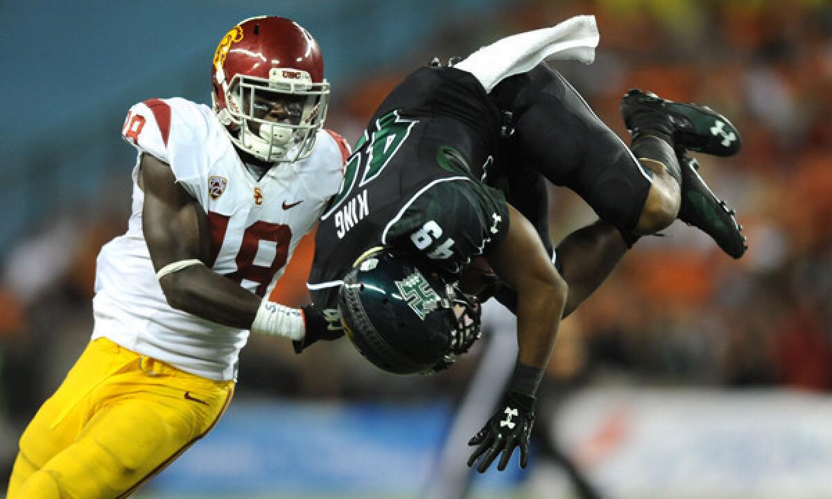 Hawaii's Donnie King Jr., right, is upended in front of USC safety Dion Bailey during the Trojans' season-opening win.