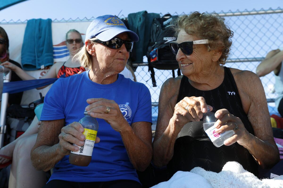 Master swimmers Bev Montrella, left, and Maurine Kornfeld, 97, try and keep cool in temperatures well over 100 degrees at the USMS Spring National Championship. (Francine Orr / Los Angeles Times)