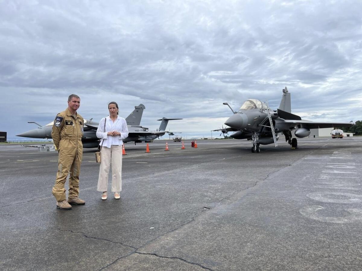 A man in uniform and a woman showcase French-made fighter jets.