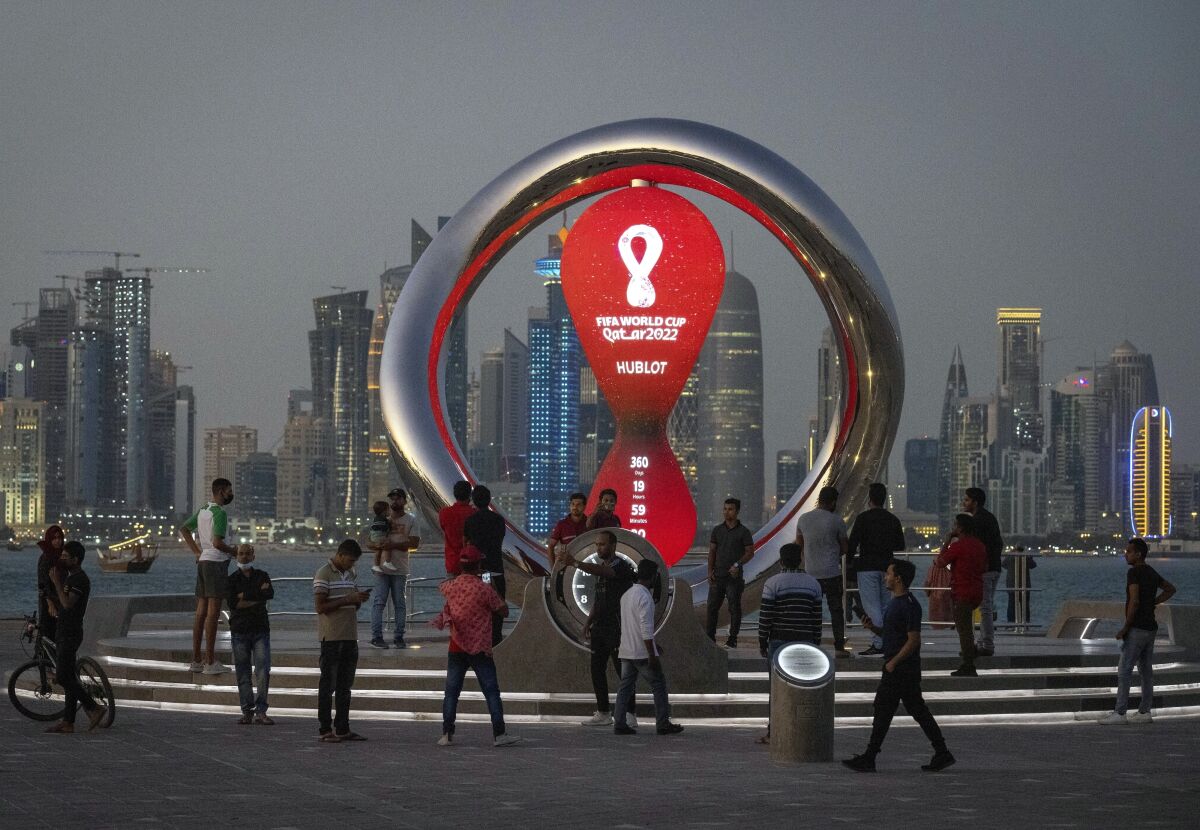 Personas se reúnen alrededor del reloj oficial que marca la cuenta regresiva hasta la inauguración de la Copa Mundial