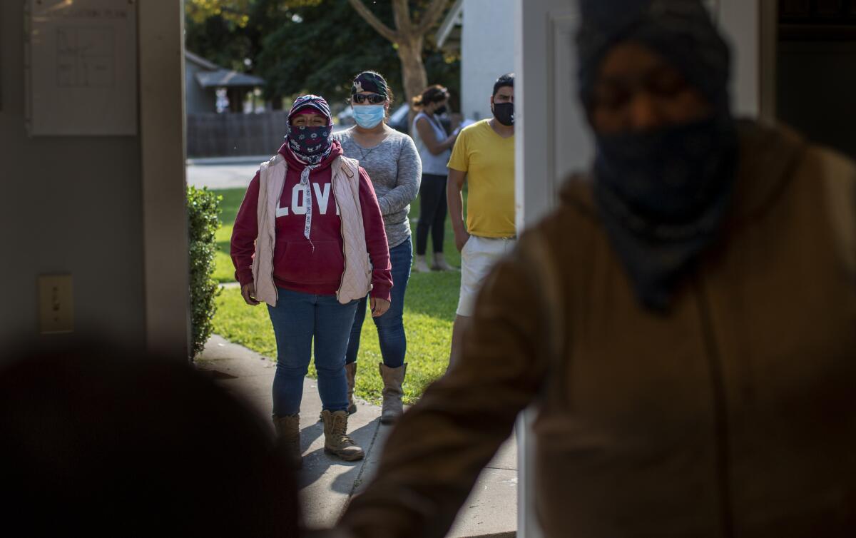 Potato farmworkers wait in line at Our Redeemer Lutheran Church to receive a $1,000 check to help cover expenses