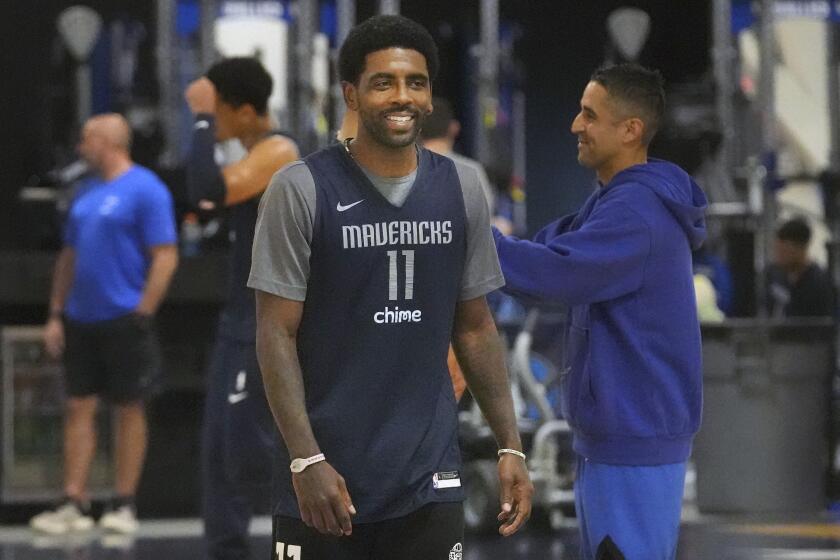 Dallas Mavericks guard Kyrie Irving smiles as he walks on the court during an NBA basketball training camp in Dallas, Thursday, Sept. 28, 2023. (AP Photo/LM Otero)