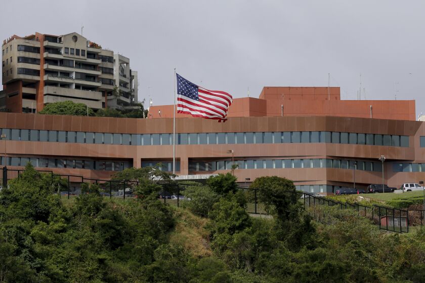 FILE - In this Jan. 24, 2019 file photo, the U.S flag flies outside the U.S. embassy in Caracas, Venezuela. U.S. charge d'affairs for Venezuela James Story and his team of fellow diplomats lowered the flag at the U.S. Embassy in March 2019, just a couple months after President Donald Trump recognized opposition leader Juan Guaido as Venezuela's legitimate leader. (AP Photo/Fernando Llano, File)