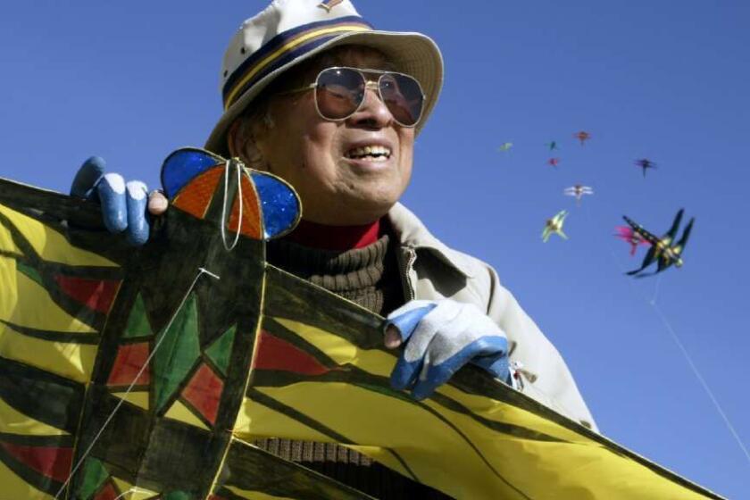 Tyrus Wong, a pioneering Chinese American artist, is seen here at the beach in Santa Monica in 2004 with some of the kites he designed and built.