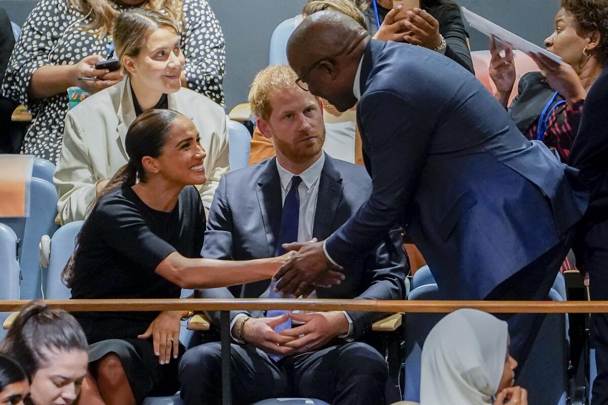 Meghan, Duchess of Sussex, left, shakes hands with Mondli Gungubele, Minister in the Presidency of South Africa, right, alongside Britain's Prince Harry, center, inside the U.N. General Assembly at its annual celebration of Nelson Mandela International Day, Monday, July 18, 2022, at United Nations headquarters. (AP Photo/John Minchillo)
