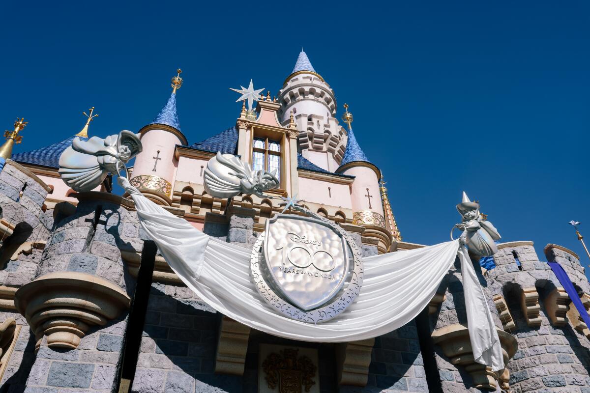 Disneyland castle with a banner draped in front for the park's 100th anniversary