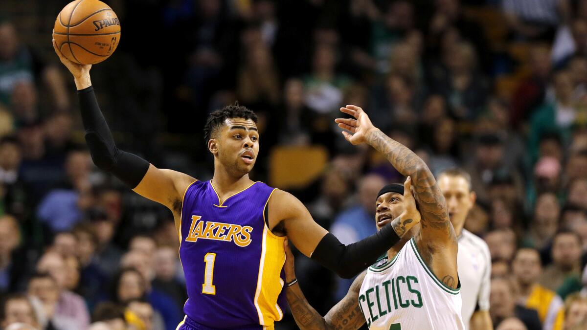 Lakers guard D'Angelo Russell (1) holds the ball away from Celtics guard Isaiah Thomas while looking to pass during the first half Friday night in Boston.