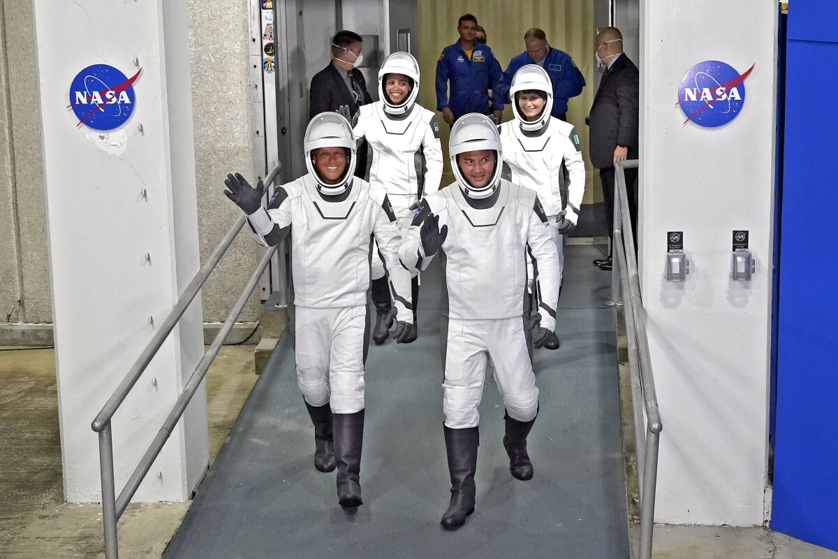 Suited astronauts waving