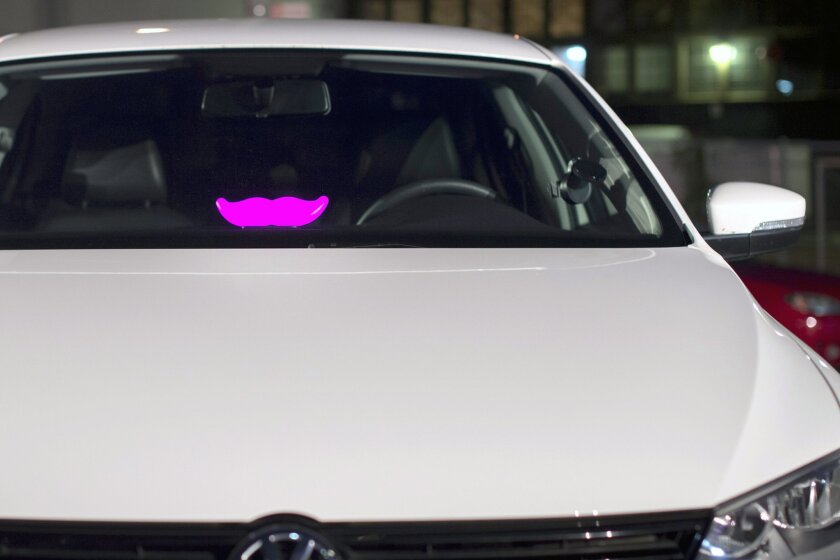 A Lyft "glowstache" rests on a dashboard of a car at the company's San Francisco headquarters.