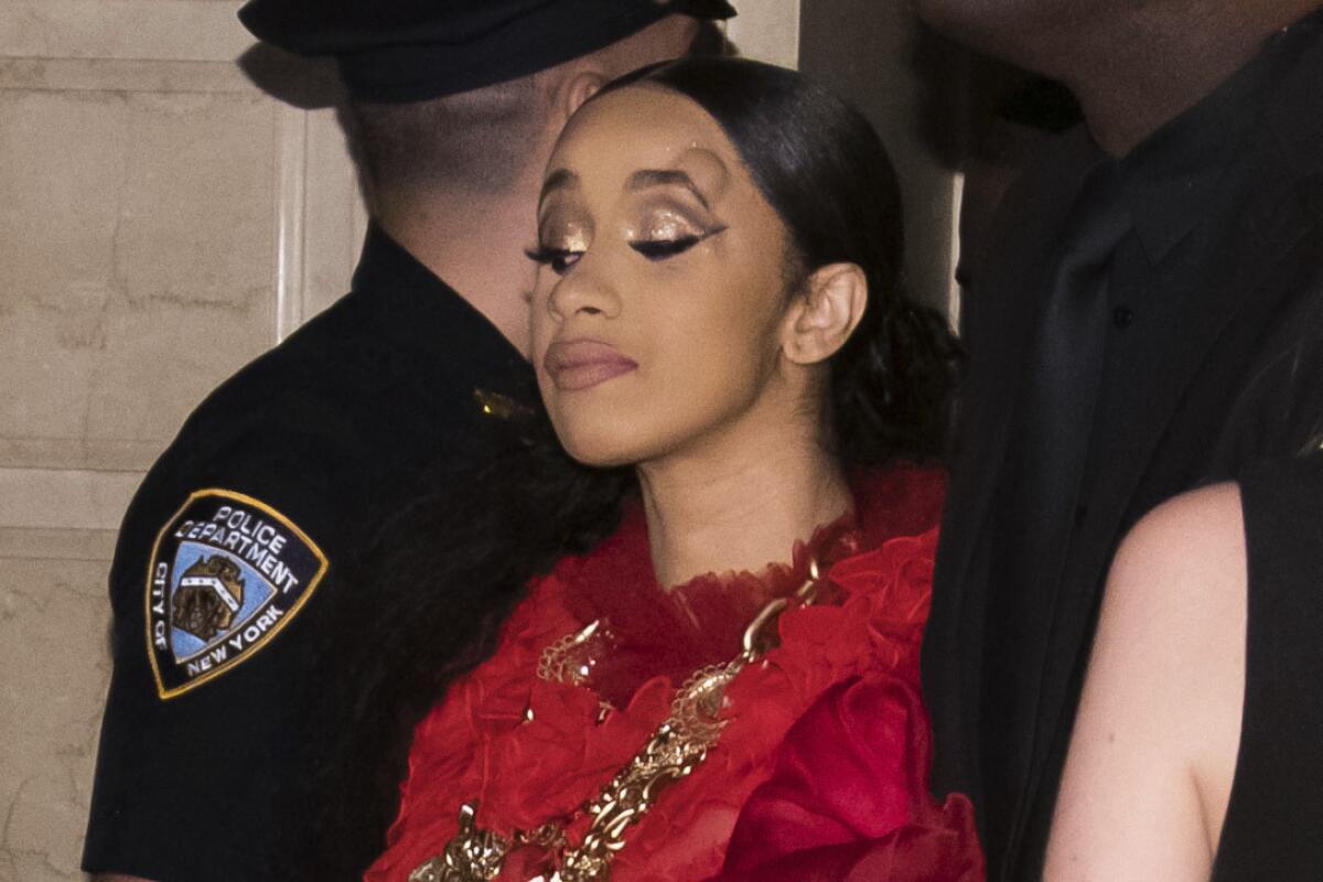 Cardi B, shown with a bump on her forehead, leaves a New York Fashion Week event after an altercation Friday.