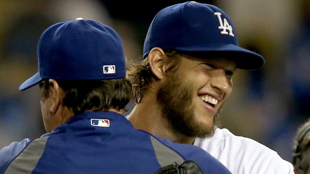 Dodgers starter Clayton Kershaw, right, is congratulated by pitching coach Rick Honeycutt after throwing a complete game against the San Diego Padres in July. Kershaw led the majors with six shutouts this season.