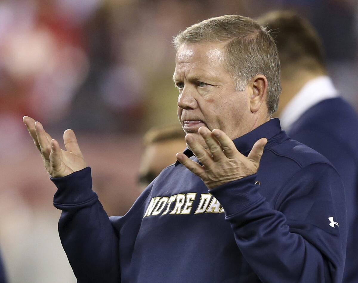 Notre Dame Coach Brian Kelly gestures to his players as they warm up before a game against Temple on Oct. 31, 2015.