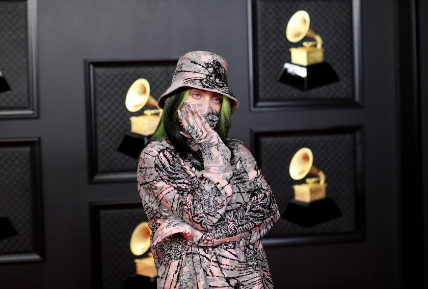 Billie Eilish with her arms crossed and hand over her mouth at the Grammys