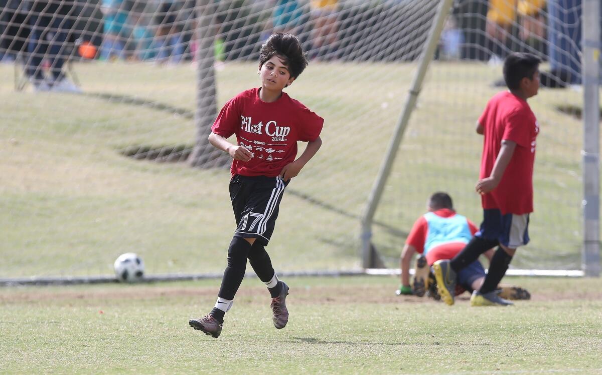 Adams Elementary's Christian Sotomayor trots upfield after scoring a goal against Kaiser in a boys' fifth- and sixth-grade Silver Division pool-play match at the Daily Pilot Cup on Friday at Jack R. Hammett Sports Complex in Costa Mesa.
