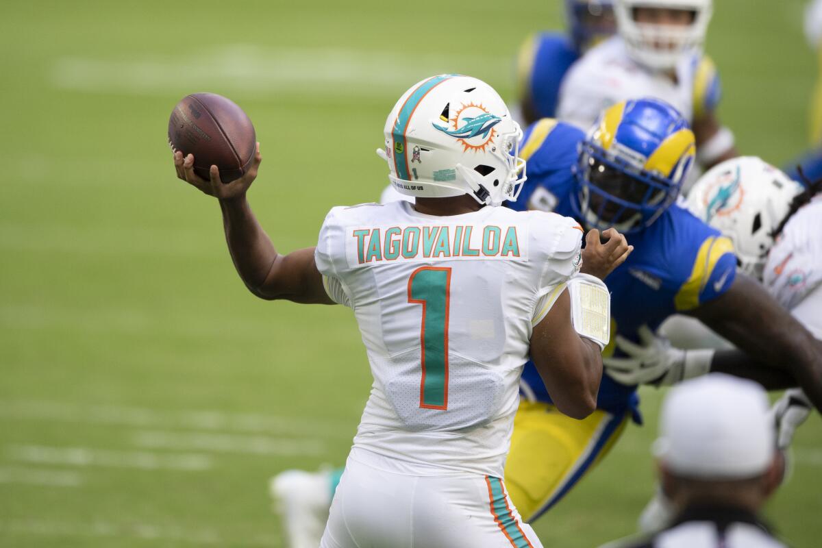 The Rams pressure Dolphins rookie quarterback Tua Tagovailoa (1) during his NFL starting debut.