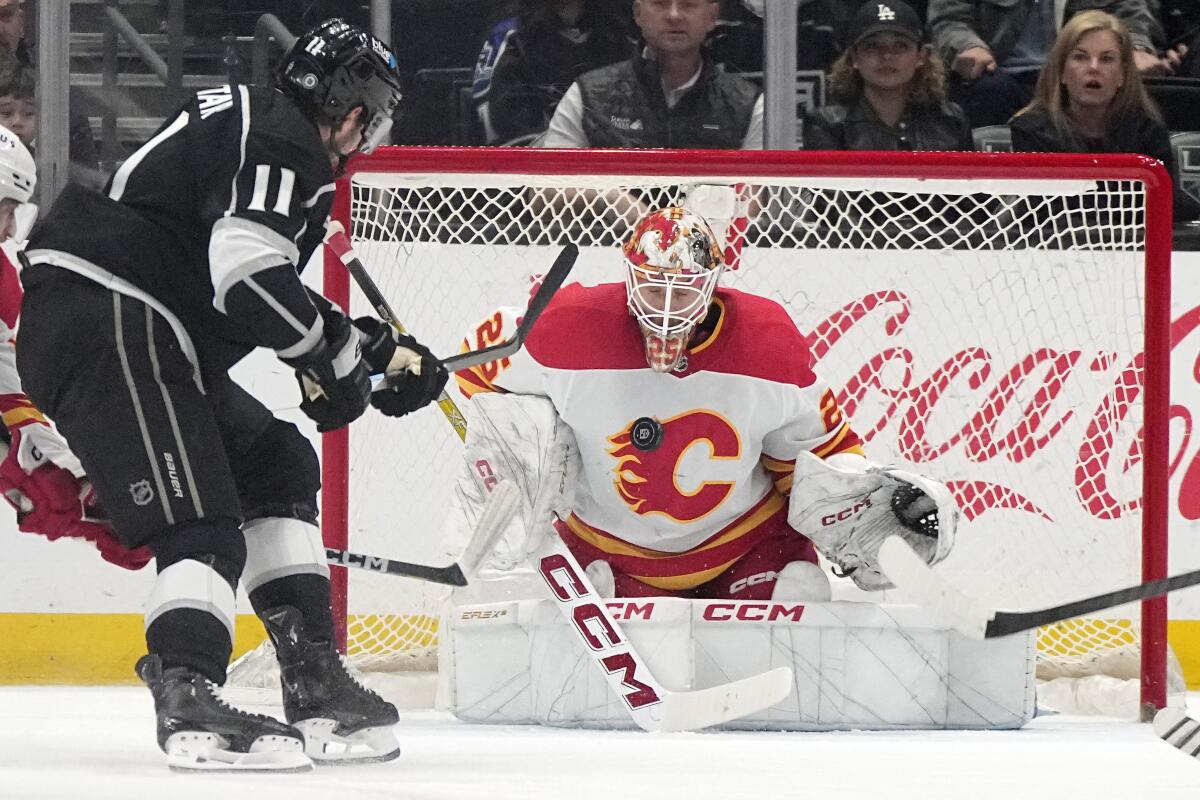Calgary Flames goaltender Jacob Markstrom, right, stops a shot by Kings forward Anze Kopitar.
