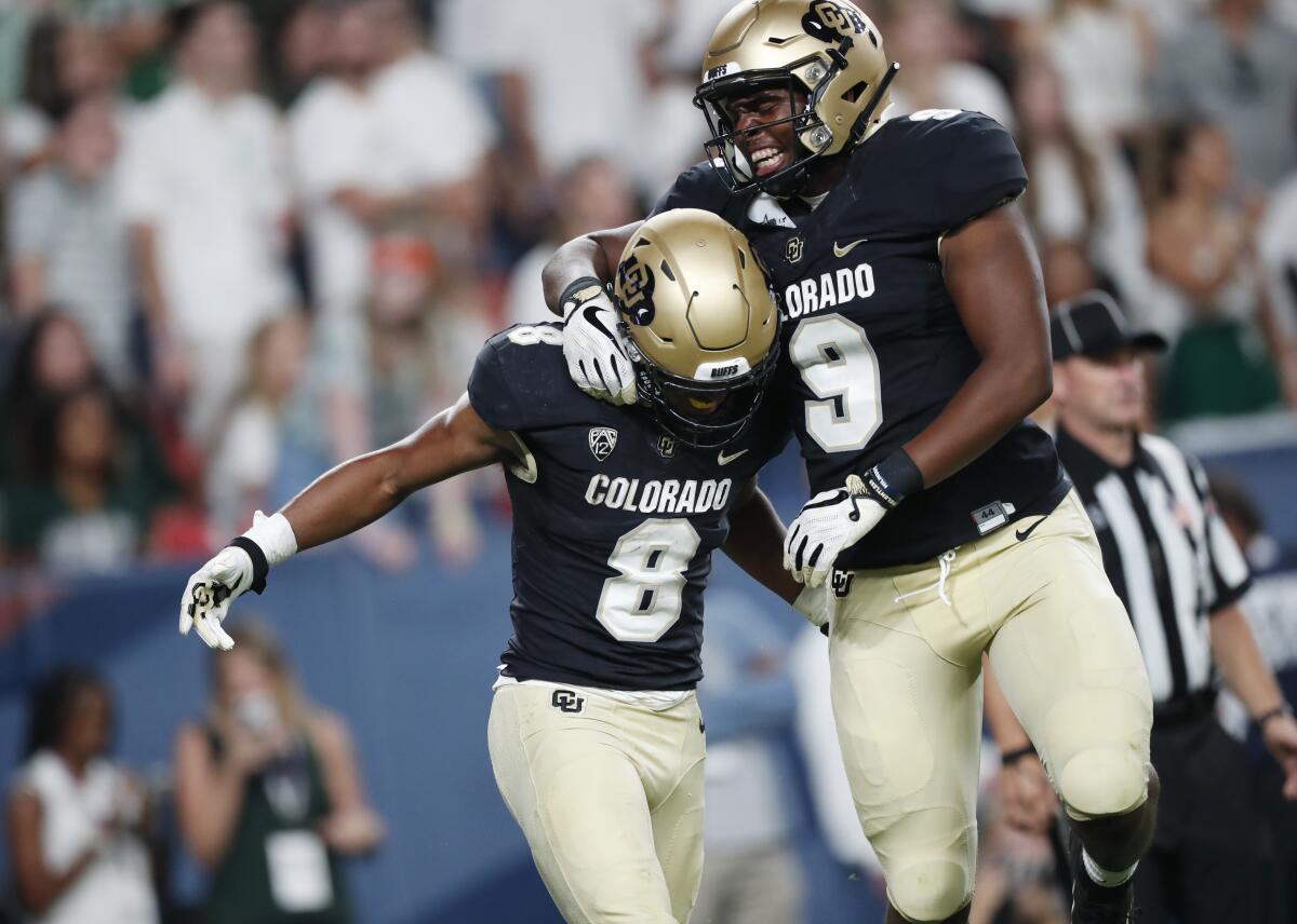 Colorado tight end Jalen Harris, right, celebrates with running back Alex Fontenot, who scored a touchdown against Colorado State in the third quarter on Friday in Denver.