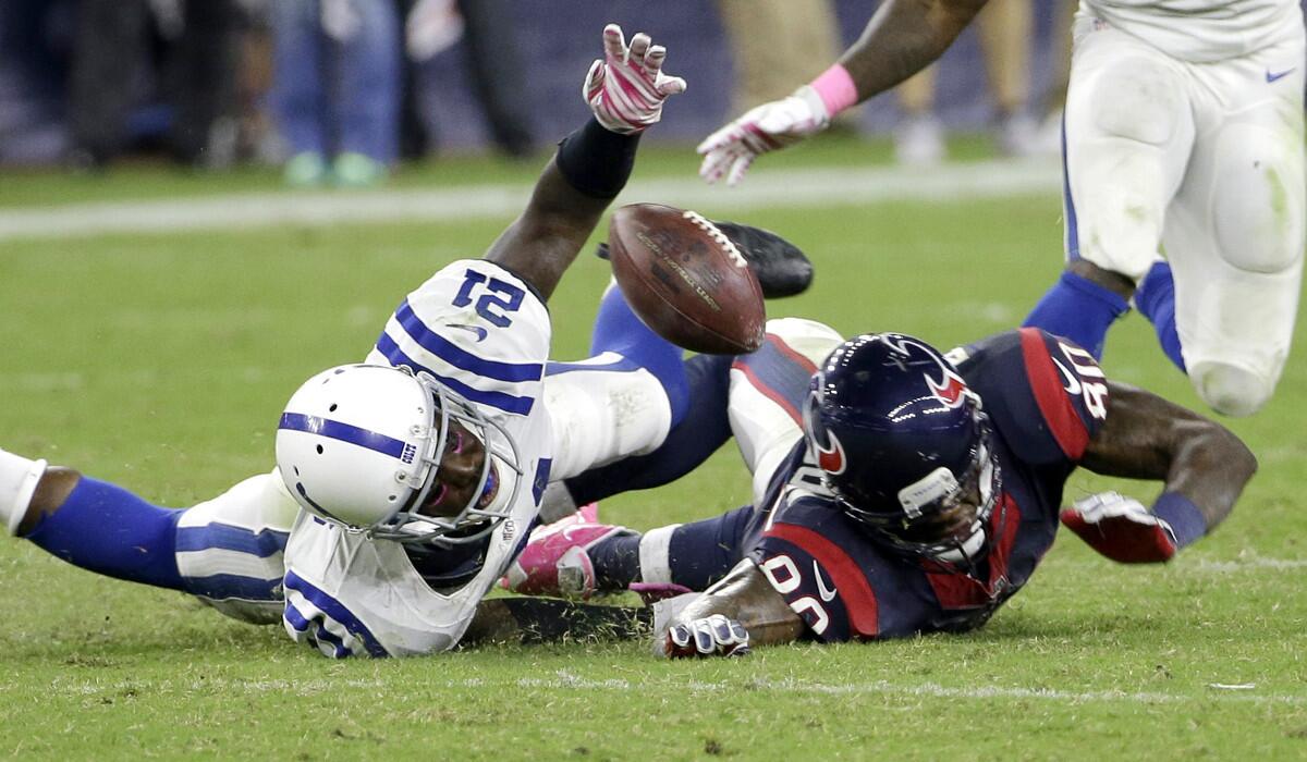 Texans receiver Andre Johnson (80) fumbles after making a reception and then getting hit by Colts cornerback Vontae Davis (21) in the fourth quarter Thursday night.