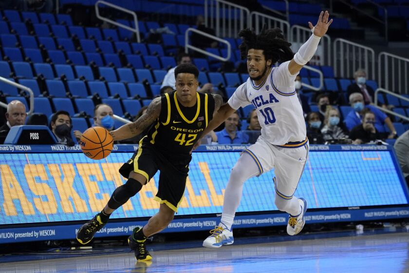 UCLA guard Tyger Campbell (10) defends against Oregon guard Jacob Young (42) during the second half of an NCAA college basketball game in Los Angeles, Thursday, Jan. 13, 2022. (AP Photo/Ashley Landis)