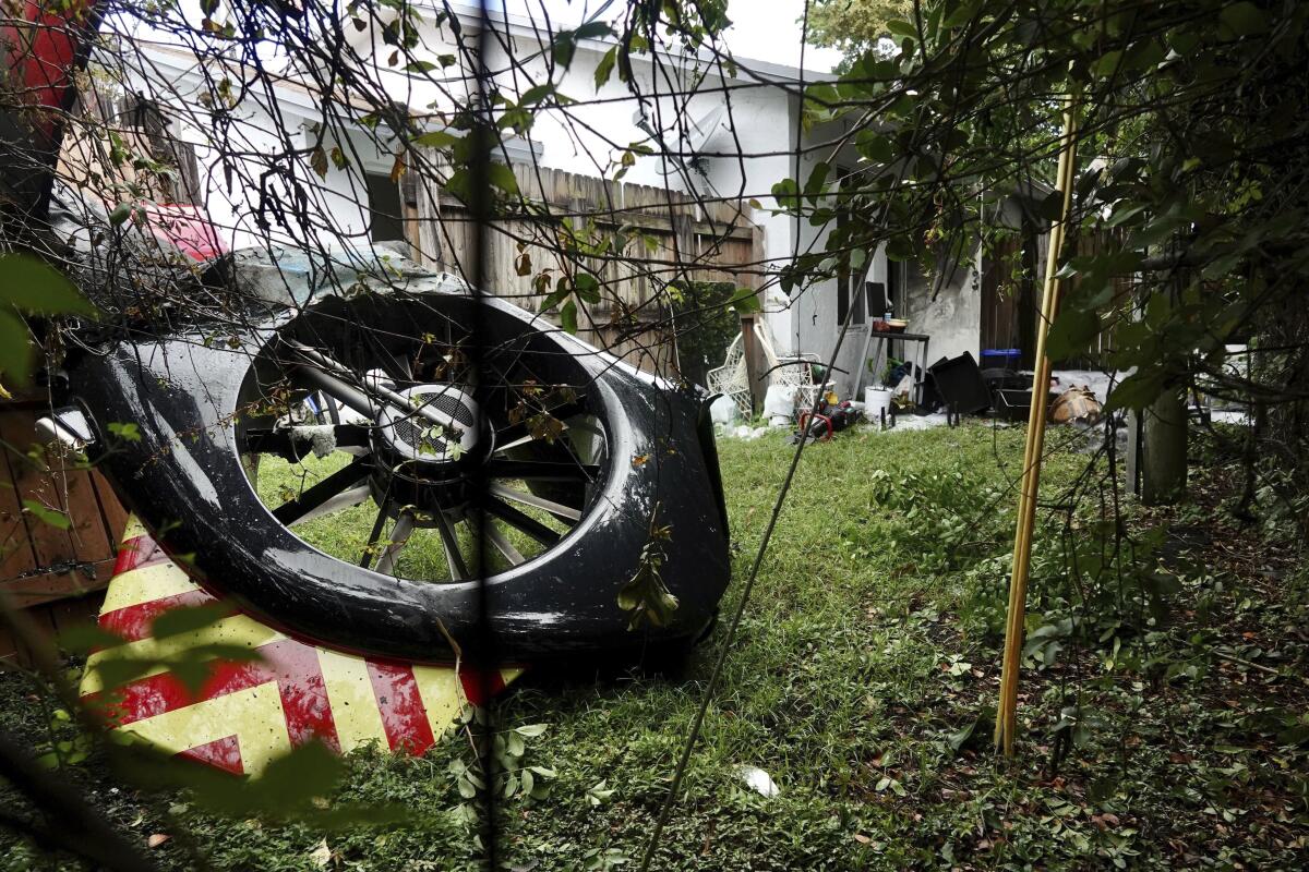 The tail rotor of a helicopter lies in the backyard of a home after crashing on Monday